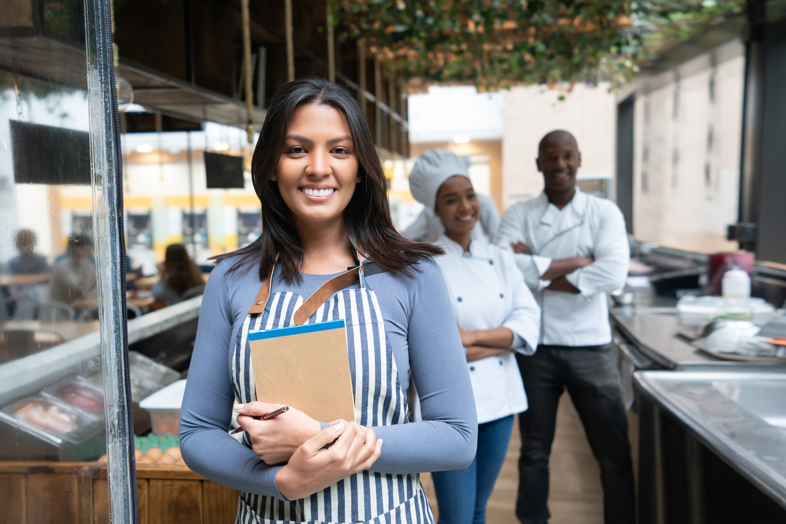 Portrait of a restaurant manager with the staff looking happy